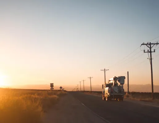 Coop Truck Driving Down Road Sundown